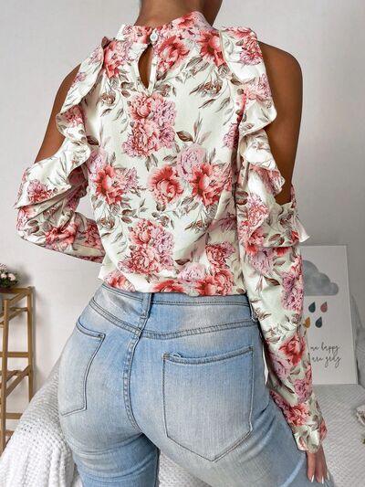 a woman wearing jeans and a floral top