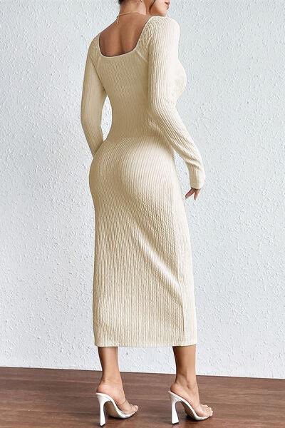 a woman in a white sweater dress standing on a wooden floor