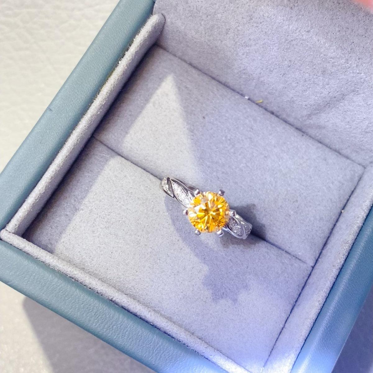 a yellow diamond ring in a blue box