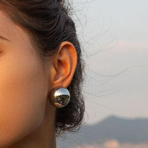 a close up of a person wearing a pair of earrings