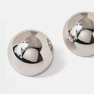 a close up of two metal knobs on a white surface