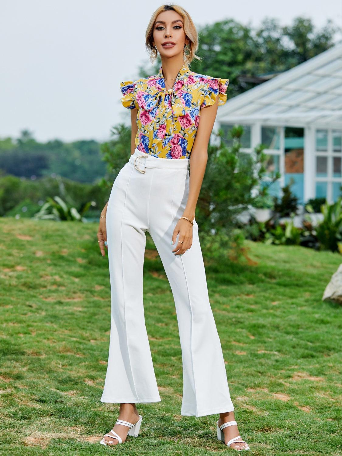 a woman in a yellow top and white pants