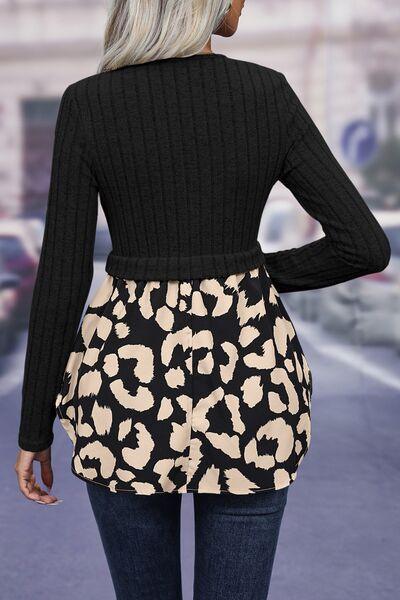 a woman wearing a black sweater and a leopard print skirt