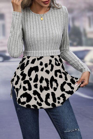 a woman in a gray sweater and leopard print skirt