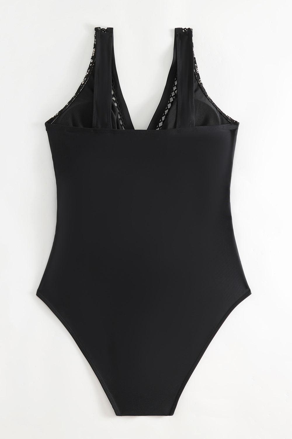 a black one piece swimsuit hanging on a wall