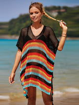 a woman standing on a beach holding a surfboard