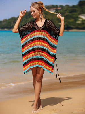 a woman walking on a beach holding a parasol