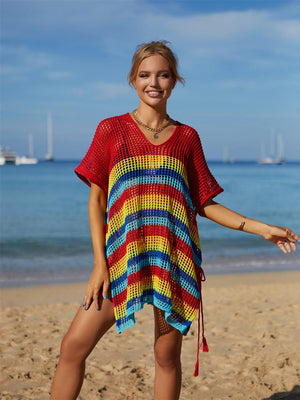 a woman standing on a beach wearing a colorful dress