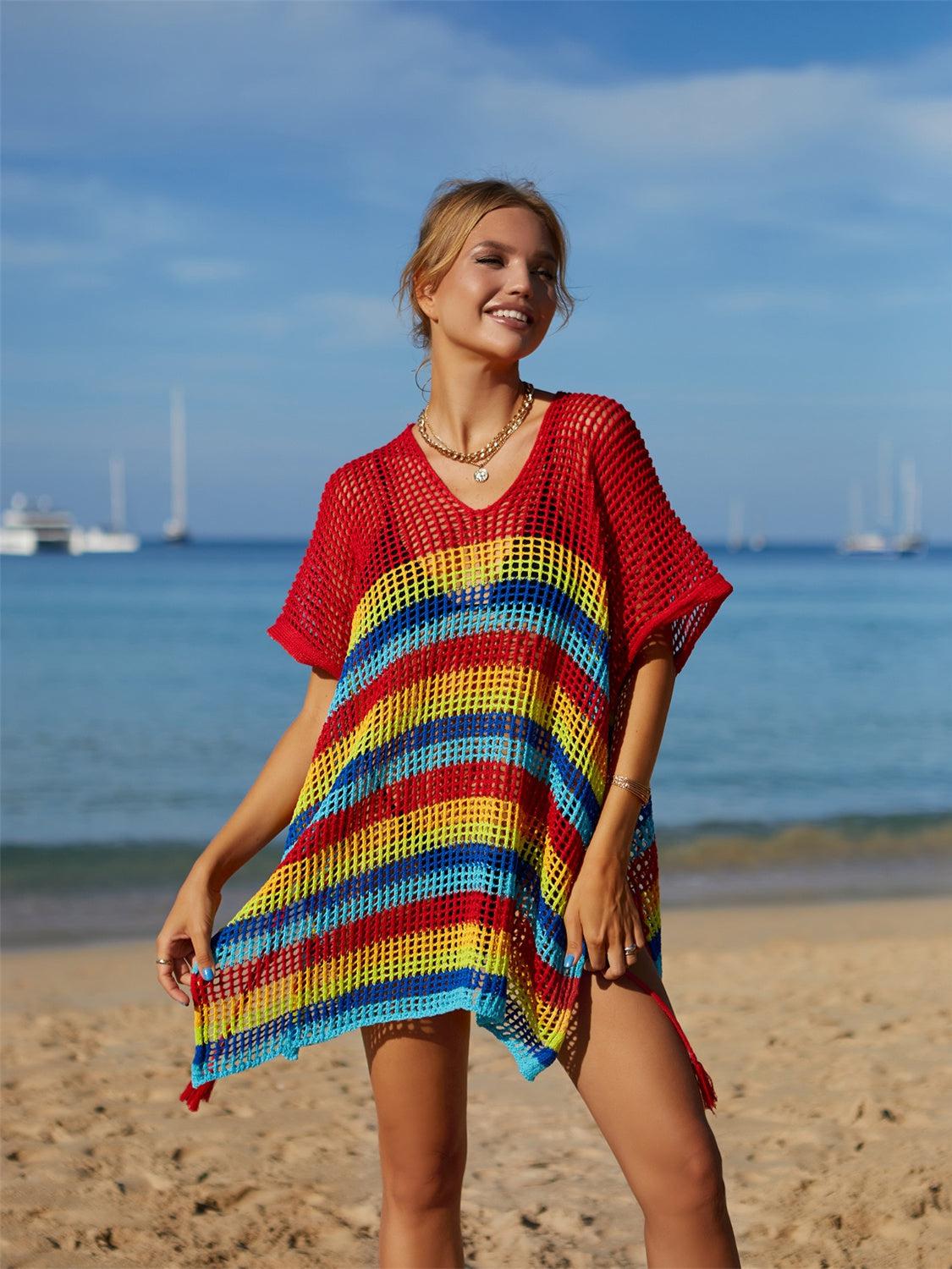 a woman standing on a beach wearing a colorful dress