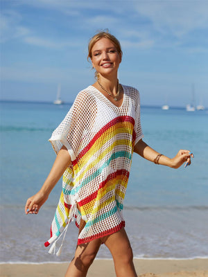 a woman walking on the beach in a colorful dress