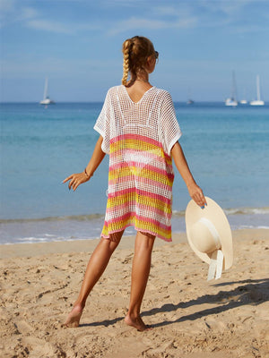 a woman standing on a beach holding a hat