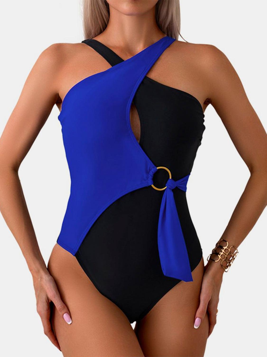 a woman wearing a blue and black one piece swimsuit
