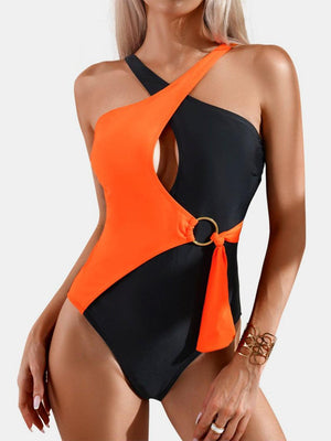 a woman wearing an orange and black one piece swimsuit