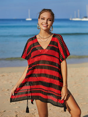 a woman standing on a beach wearing a red and black dress