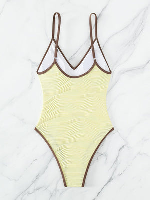 a yellow and brown swimsuit on a marble surface