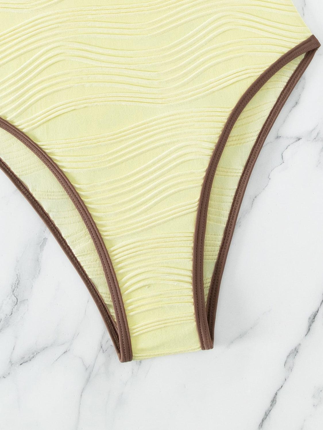 a women's yellow and brown bikini bottom on a marble surface