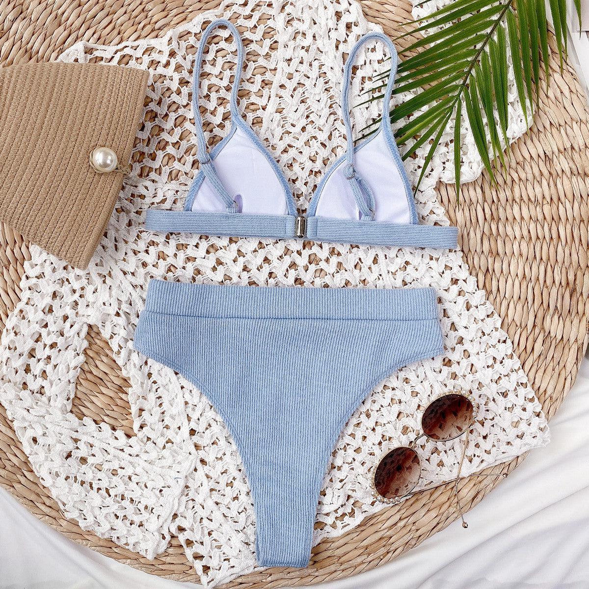 a woman's blue and white bikinisuit with a straw hat and sunglasses