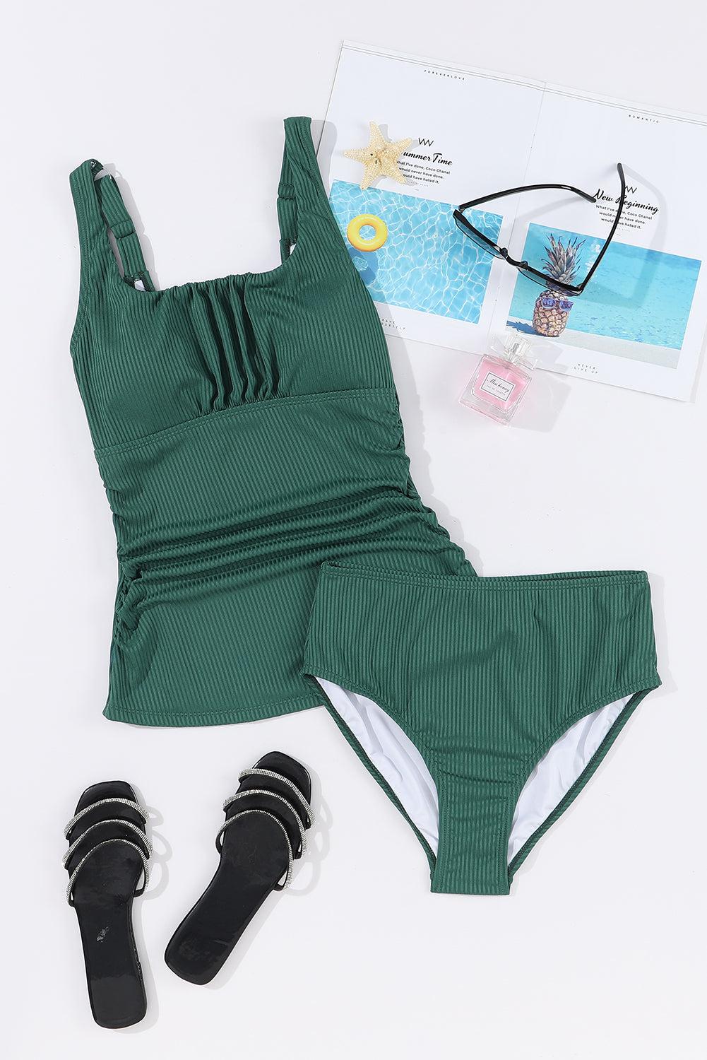 a woman's green swimsuit and sunglasses on a white surface