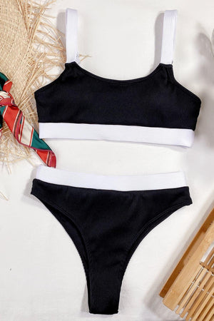 two pieces of black and white swimsuit next to a bamboo comb