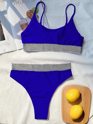 a woman's blue bikinisuit and a lemon on a bed