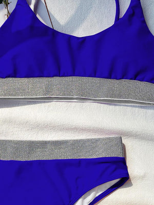 a blue and white swimsuit laying on top of a towel