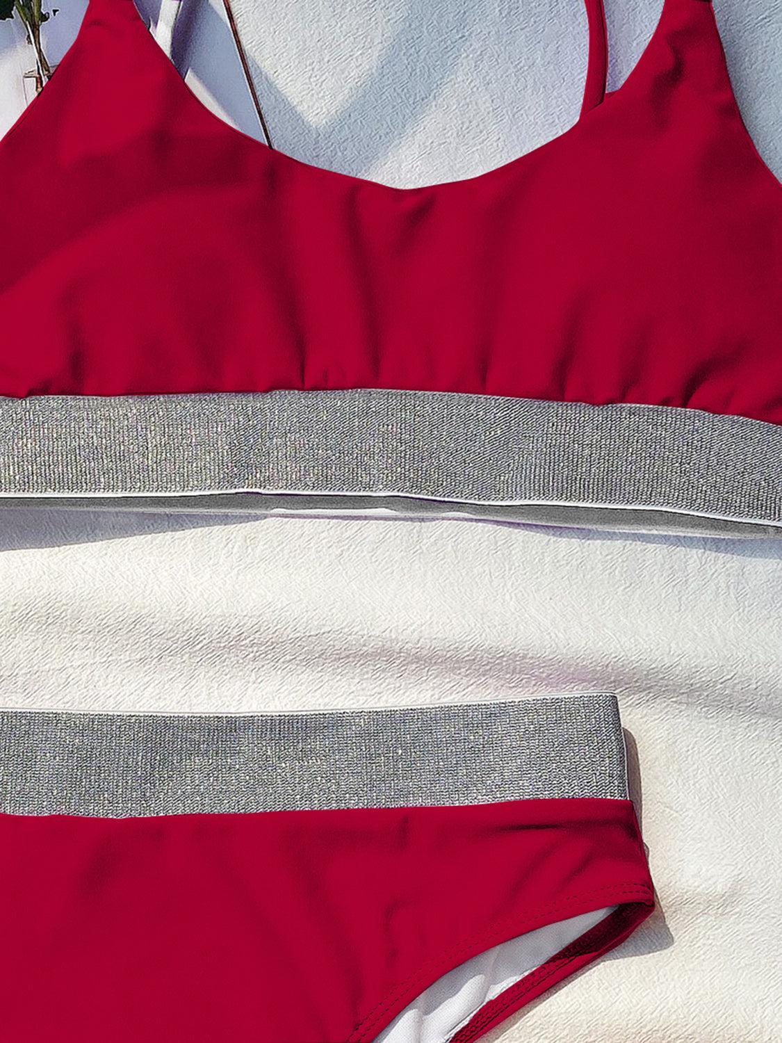 a red and white swimsuit laying on top of a towel