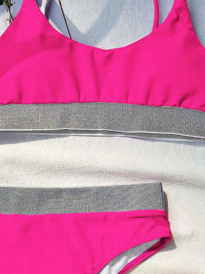 a woman's pink and grey swimsuit laying on a bed