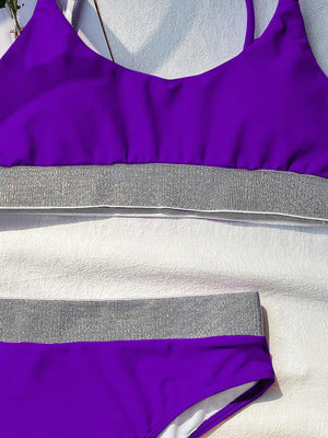 a purple and white swimsuit laying on top of a towel
