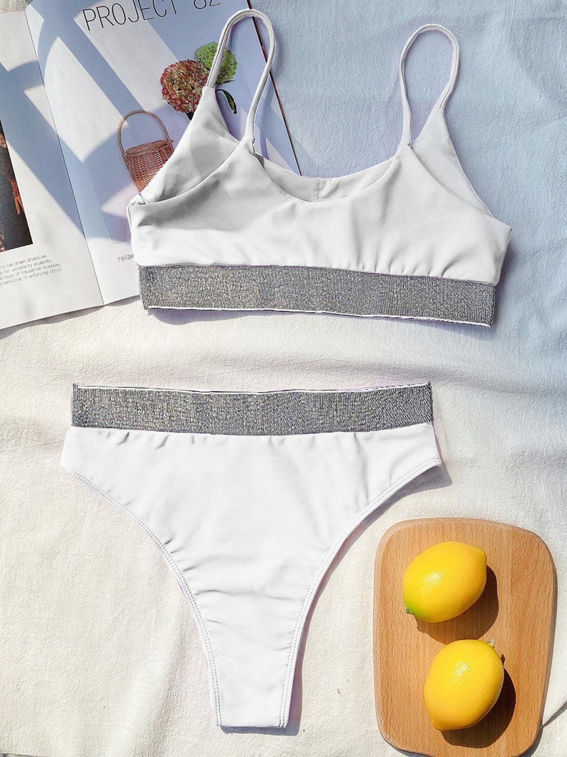 a bikini top and two lemons on a bed