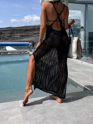 a woman in a black dress is walking by a pool
