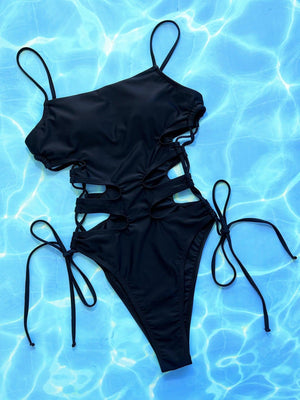 a black swimsuit laying on top of a blue pool