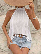 a woman wearing a straw hat sitting on the beach