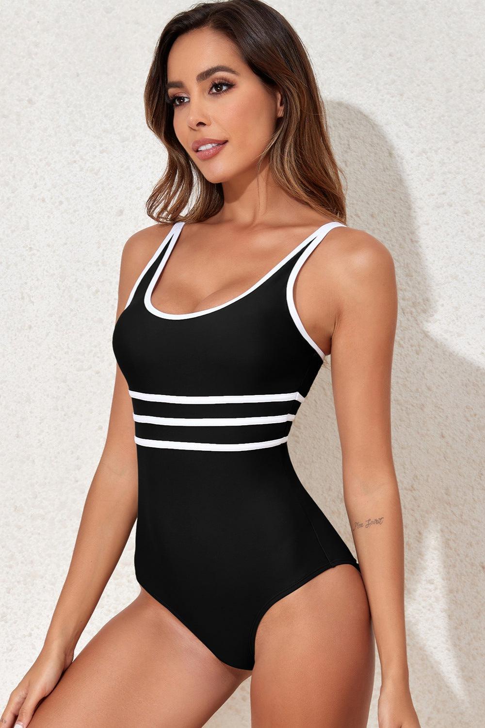 a woman in a black and white one piece swimsuit