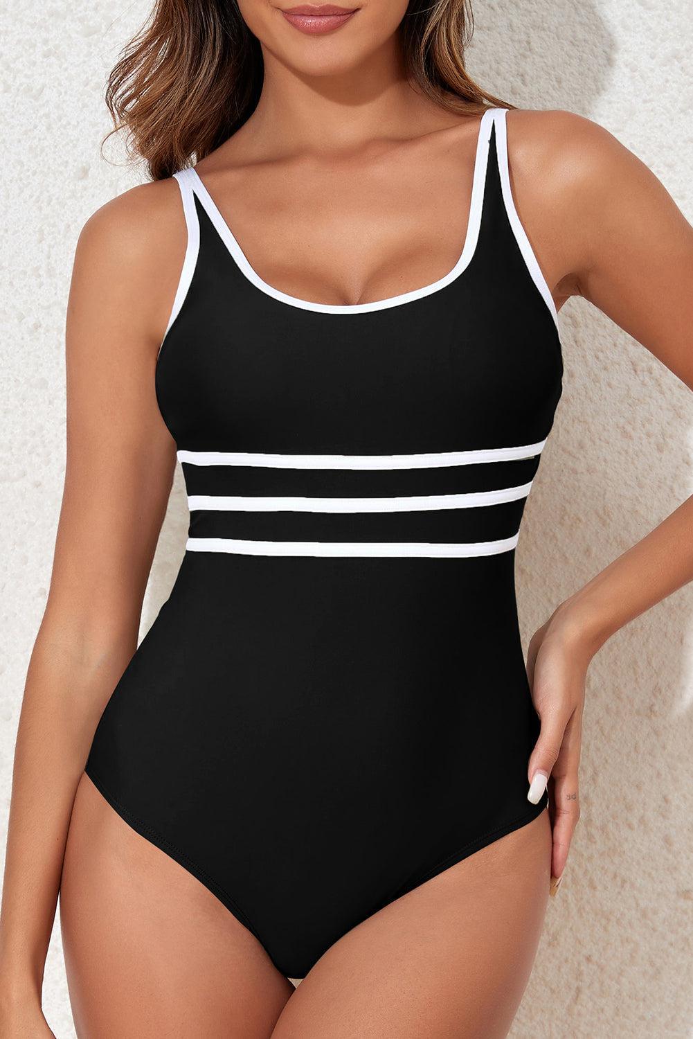 a woman in a black and white one piece swimsuit