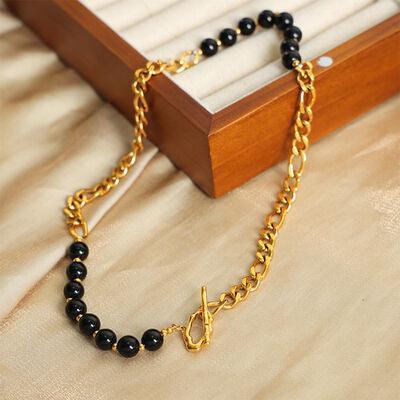 a black beaded necklace with a gold chain