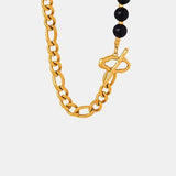 a black beaded necklace with a gold chain