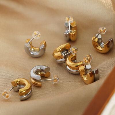 a group of gold and silver earrings sitting on top of a table