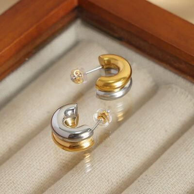 a pair of gold and silver earrings in a box