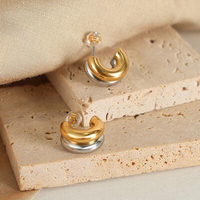 a pair of earrings sitting on top of a piece of stone