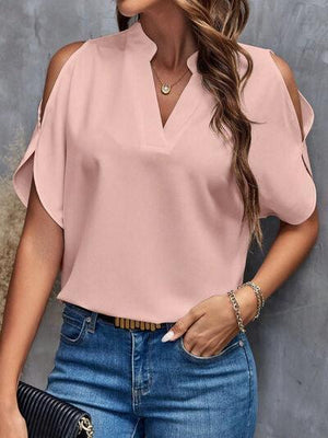 a woman wearing a pink blouse and jeans