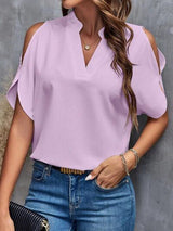 a woman wearing a purple blouse and jeans