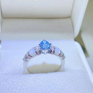 a ring with a blue stone in a white box