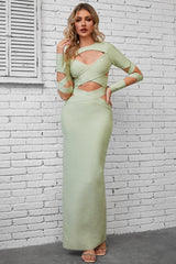 a woman wearing a green dress with cut out shoulders