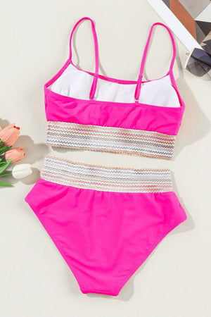 a pink and white one piece swimsuit next to flowers