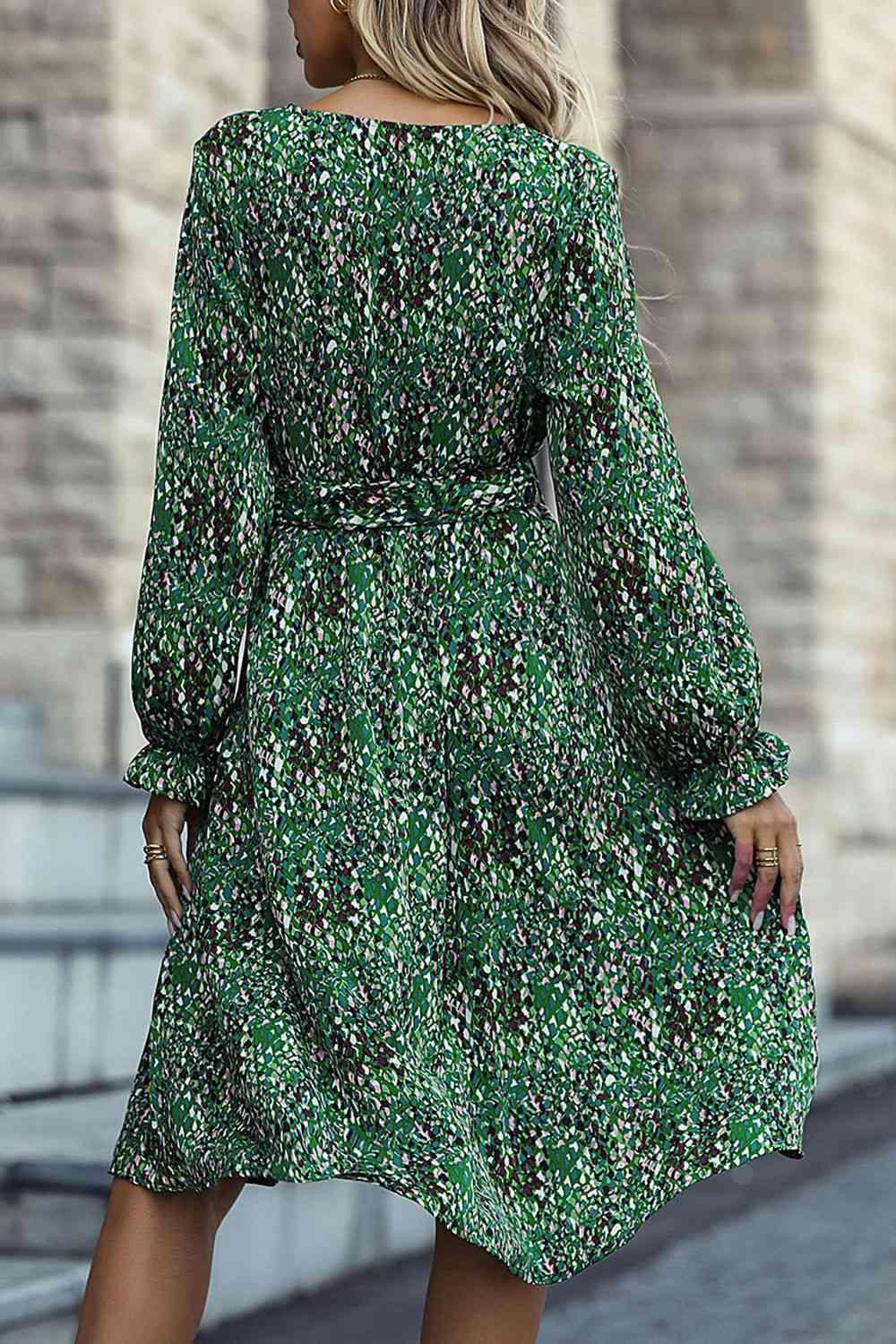 a woman wearing a green floral print dress