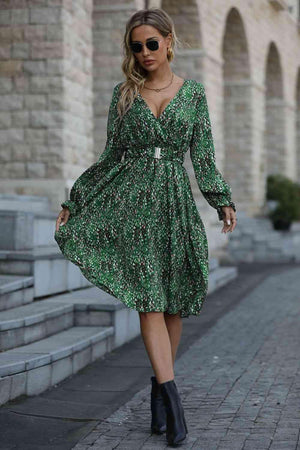 a woman in a green dress is walking down the street