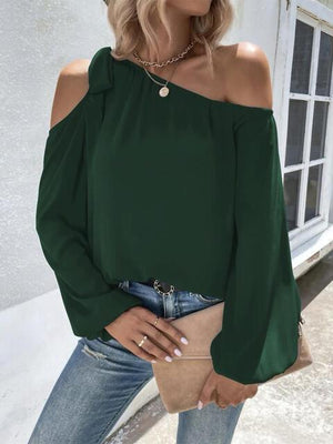 a woman wearing a green top and jeans