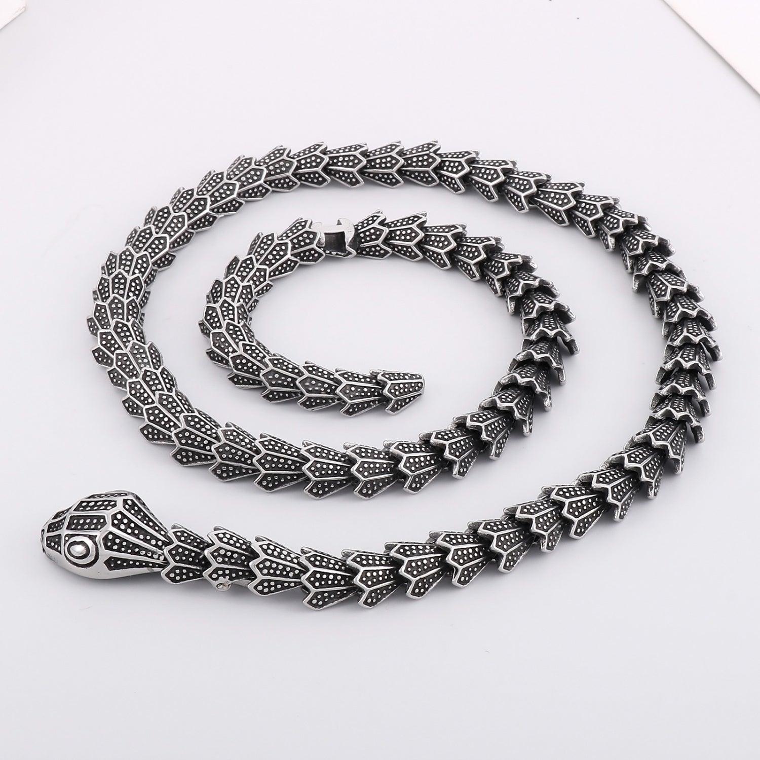 a silver necklace with a snake on it