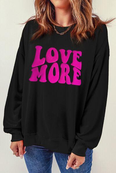 a woman wearing a black sweatshirt with the words love more printed on it