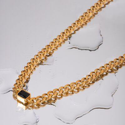 a gold chain with a black stone on it